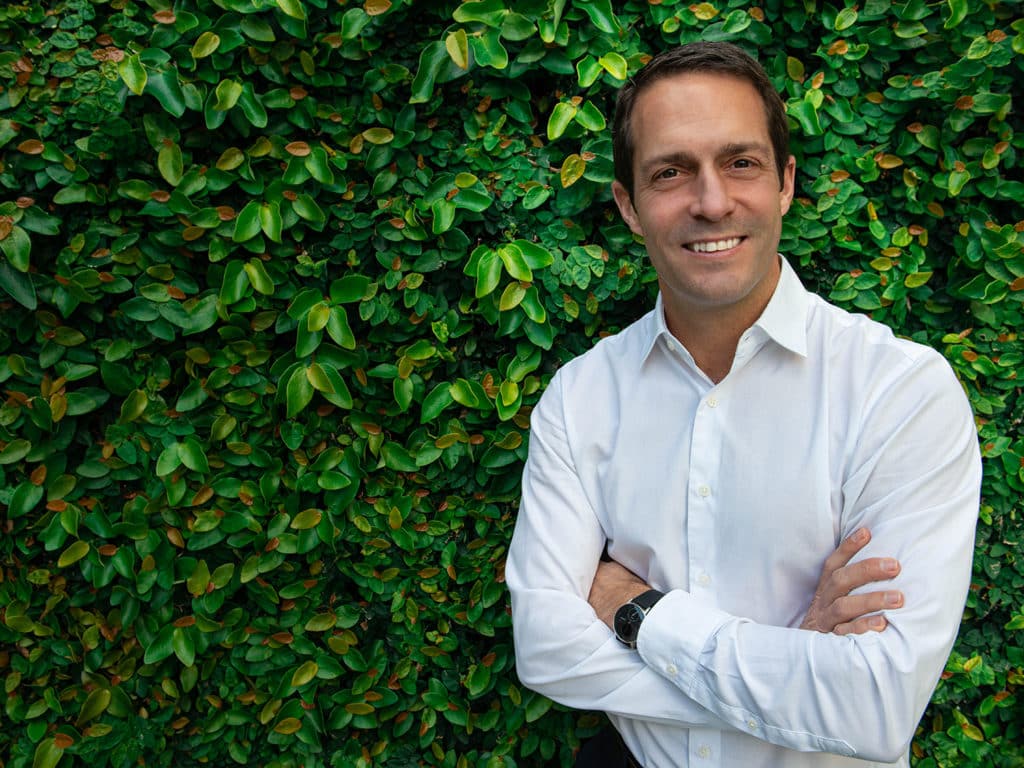 Nicholas Bruneau standing in front of a green vertical garden.